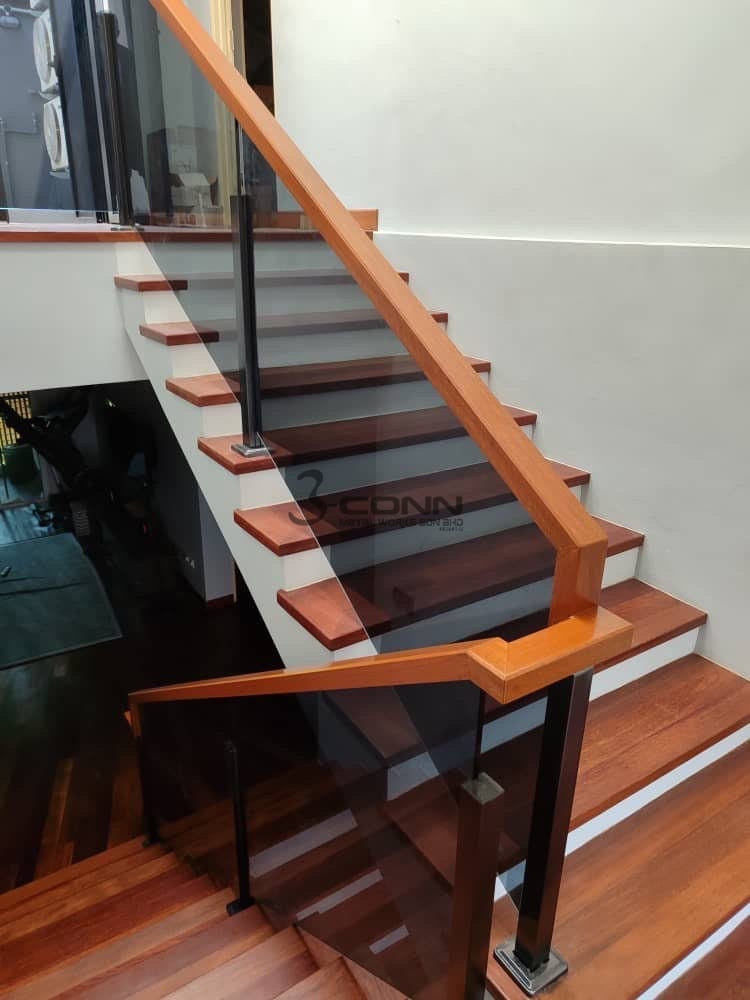 A tempered glass railing in a titanium-coated stainless steel frame with a timber handrail, on a flight of timber treads.
